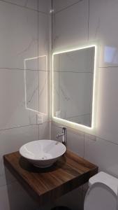 a bathroom with a sink and a mirror and a toilet at Orion department in Tepic +16 photos