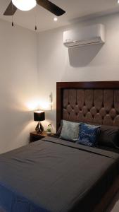a bedroom with a large bed with a brown headboard at Orion department in Tepic
