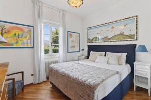 a bedroom with a blue and white bed and a window at Casa Donata by Gottschalk in Lierna +66 photos