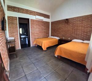 two beds in a room with a brick wall at Villa Esmeralda del Mar in Monte Gordo +31 photos