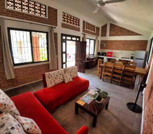 a living room with a red couch and a kitchen at Villa Esmeralda del Mar in Monte Gordo