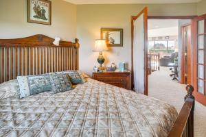 a bedroom with a large bed with a wooden headboard at Charming Sequim House w/ Olympic Peninsula Views! in Sequim