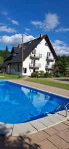 a large swimming pool in front of a building at Noclegi pod Brzegiem in Zawoja