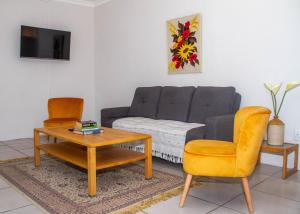 a living room with a couch and a table at Cote Cottage in Somerset West