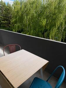 a wooden table and two chairs on a balcony at Chambre privative Paris 13e in Paris