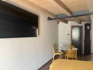 a dining room with a table and a tv on the wall at La Crevasse Morgex in Morgex