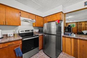 a kitchen with wooden cabinets and a stainless steel refrigerator at Nantahala Ridge in Bryson City