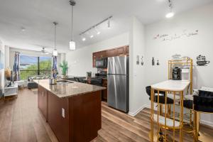 a kitchen and living room with a refrigerator and a counter at Spacious Blessed HOME for blessed guests at the Domain in Austin