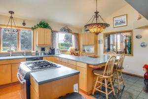 a kitchen with a stove and a island with chairs at Unique Home w/ Beautiful Mtn Views! in Sequim