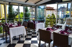 Un restaurante con mesas, sillas y ventanas. en Ark Apart and Suite Hotel, en Alanya