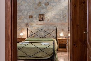 a bedroom with a bed and a stone wall at Capracotta in Montemassi +56 photos