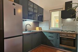a kitchen with green cabinets and a refrigerator at Casa Oliva Kim Marie /w Garden - Happy Rentals in Medulin
