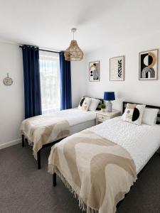 two beds in a bedroom with blue curtains at GALLOWGATE - CITY CENTRE - Free PRIVATE PARKING in Aberdeen