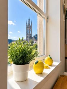 two oranges on a window sill with a view of a church at GALLOWGATE - CITY CENTRE - Free PRIVATE PARKING in Aberdeen