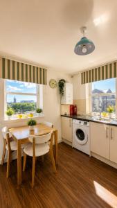 a kitchen with a table and a dining room at GALLOWGATE - CITY CENTRE - Free PRIVATE PARKING in Aberdeen