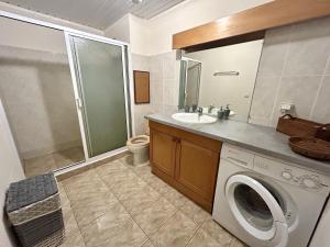a bathroom with a washing machine and a sink at TAHITI - Condo Ariitea in Pirae