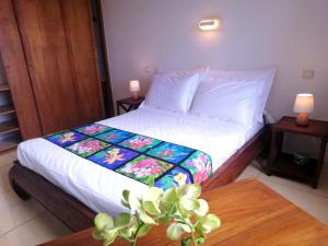 a bedroom with a bed and a table with a table sidx sidx sidx at TAHITI - Condo Ariitea in Pirae