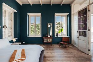 a bedroom with blue walls and a bed and windows at Villa Tokara in Willemstad +62 photos