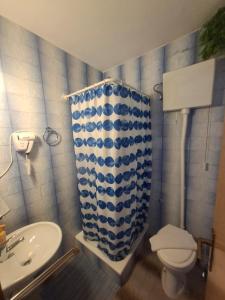 a bathroom with a toilet and a sink and a shower curtain at Malin Guesthouse in Skradin