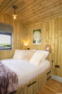 a bedroom with a bed in a wooden cabin at Valentine in Longdown +10 photos
