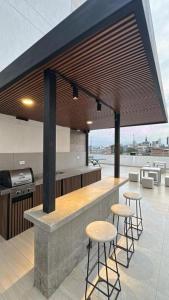 a kitchen with stools and a bar with a view at Torre U kooliving in Manizales