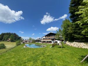 a house with a swimming pool in a yard at Bärnsicht Panorama Hotel in Wasen