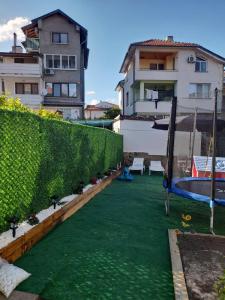 a backyard with a green lawn and a pool at Lux Maisonette in Chernomorets