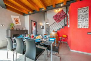 a dining room with a table and chairs and a red wall at Villa Laura Private Pool and Garden near Lake Maggiore for 9 - Happy Rentals in Besozzo +43 photos