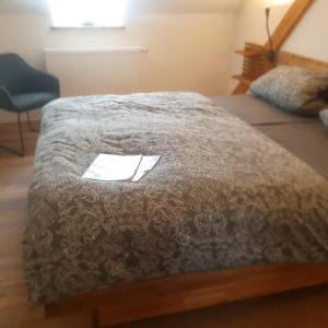 a bed with a brown comforter in a room at Ferienwohnung Vital am Bach "Dhron" in Neumagen-Dhron