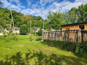 a wooden fence in a yard with a house at Ferienwohnung Vital am Bach "Dhron" in Neumagen-Dhron