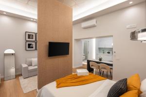 a bedroom with a bed and a tv on a wall at Altrove Boutique Studios in Caserta
