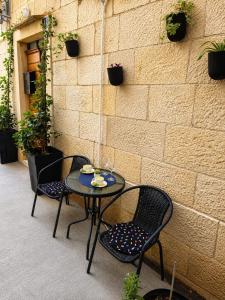 a table and two chairs sitting next to a brick wall at Komiža Sea Breeze in Komiža