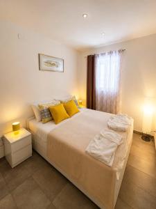 a bedroom with a large bed with yellow pillows at Komiža Sea Breeze in Komiža
