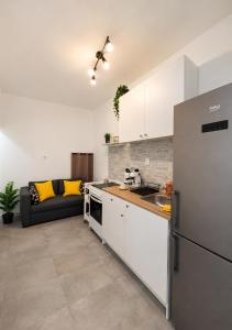 a kitchen with a refrigerator and a couch in a room at Komiža Sea Breeze in Komiža