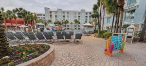 a patio with chairs and tables and a building at Holiday Inn Resort Orlando - Lake Buena Vista by IHG in Orlando