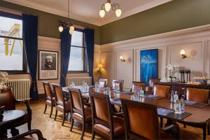 una sala conferenze con un lungo tavolo e sedie di Titanic Hotel Belfast a Belfast