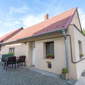 a house with a table and chairs and a roof at Biró Vendégház in Sármellék