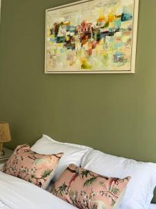 a bed with two pillows and a painting on the wall at Perle Verte de Gammarth in Tunis