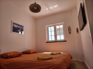 a bedroom with a bed with two green pillows on it at North Wind House in Peniche