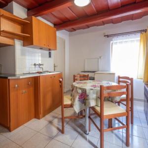 a kitchen with a table and chairs and a sink at Biró Vendégház in Sármellék