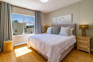 a bedroom with a large bed and a window at 75 Cap D'Azur in Strand +16 photos