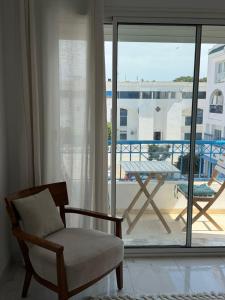a living room with a chair and a balcony at Perle Verte de Gammarth in Tunis
