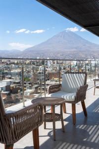 a balcony with a chair and a table and a mountain at Luxury Towers Arequipa in Arequipa