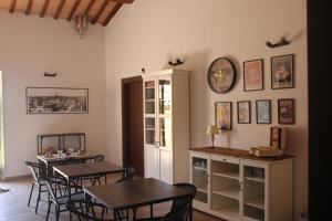 a dining room with tables and chairs and a clock on the wall at B&B del Borgo in Ortezzano