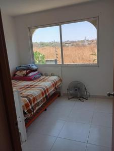 a bedroom with a bed and a large window at Vacation home with lake access and pool in Tequesquitengo
