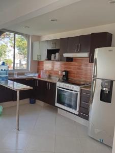 a kitchen with brown cabinets and a white refrigerator at Vacation home with lake access and pool in Tequesquitengo