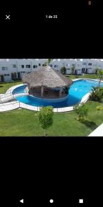 a picture of a swimming pool with a straw hut at Vacation home with lake access and pool in Tequesquitengo