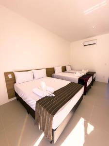 two beds in a hotel room with towels on them at Pousada Brisa dos Lençóis in Barreirinhas