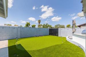 a backyard with a yard of artificial grass at Old Town Fashion(ed)-Pool-Putting Green-BBQ Grill in Scottsdale