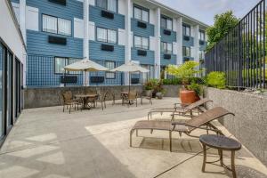 a patio with chairs tables and umbrellas in front of a building at Best Western Seattle Airport Hotel in SeaTac